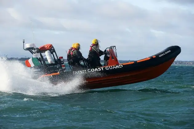 Rigid inflatable boat operating at speed on open water with crew on deck